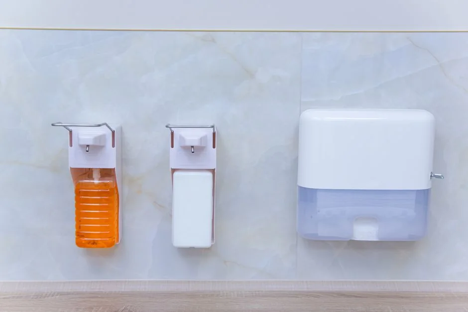 A hotel housekeeper neatly stacks fresh towels in a luxurious room setting.